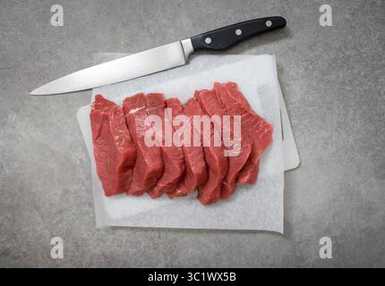 fresh raw sliced beef meat on cutting board, top view Stock Photo