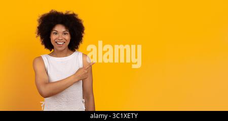 Happy African American woman pointing aside at copy space with finger Stock Photo