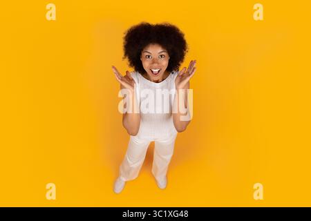 Above view of excited young African American woman looking up with surprise Stock Photo