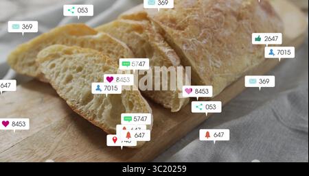 Partially sliced baguette resting on wooden cutting board on grey tabletop, with notification icons Stock Photo