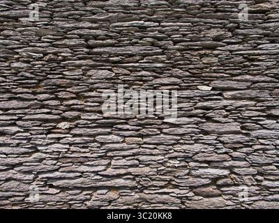 Close-up of an ancient stone wall in Ireland, highlighting the rugged texture and historic craftsmanship. Stock Photo
