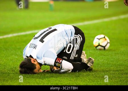 Lionel Messi of Argentina goes down clutching his leg during the FIFA