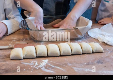Woman preparing traditional cinnamon rolls in kitchen Stock Photo