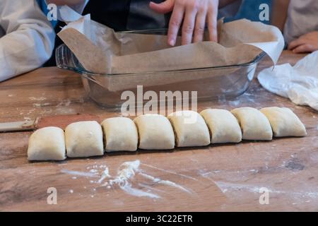 Woman preparing traditional cinnamon rolls in kitchen Stock Photo