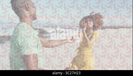 Kneeling man offering small jewelry box to woman in yellow sundress on sandy beach, proposal Stock Photo