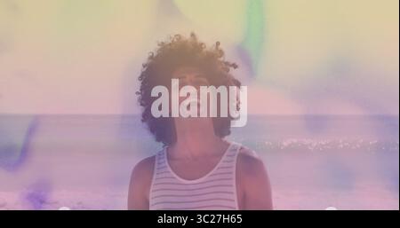 Laughing man wearing striped tank top standing at sandy beach, with pastel light leaks Stock Photo
