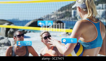 Female player wearing blue tank grey visor serving volleyball on beach with yellow net, copy space Stock Photo
