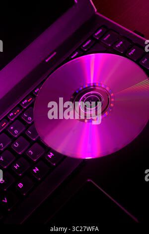 Compact disc sitting on a laptop computer Stock Photo