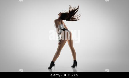 Energetic dancer in high heels strikes a dynamic jazz funk pose Stock Photo