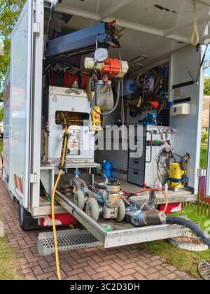 July 14, 2025 - Klockenhagen-Germany: Rear view into a service truck reveals sewer cleaning robots on a sliding rack, hoses, tools, and an overhead ho Stock Photo