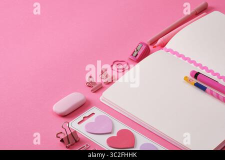 Stationery background in pink color, open notepad and office supplies. A place for your text. Stock Photo