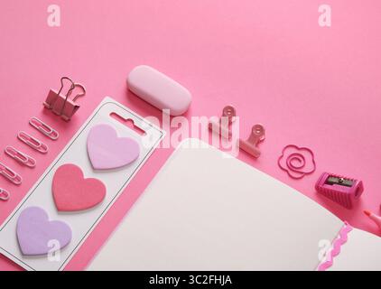 Stationery flatlay in pink theme, blank sheet of open notepad and office supplies. A place for your text. Stock Photo