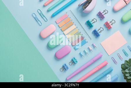 Stationery with markers, felt-tip pens, paper clips, erasers, stapler, pastel-colored stickers neatly arranged on a light blue and mint green backgrou Stock Photo