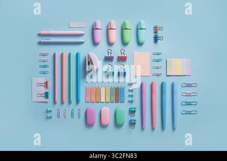 Pastel-colored stationery neatly arranged on a light blue background. Workplace organization. Back to school concept. Stock Photo