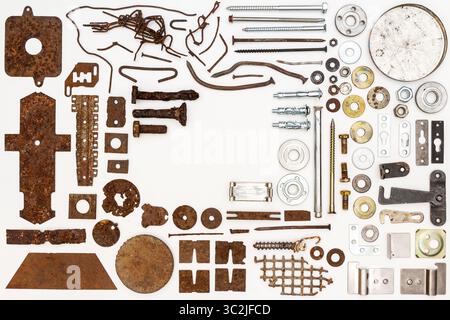 A group of various old and new bits and pieces arranged on white. Old rusty nuts, bolts, nails and other parts flay lay on white background. Stock Photo