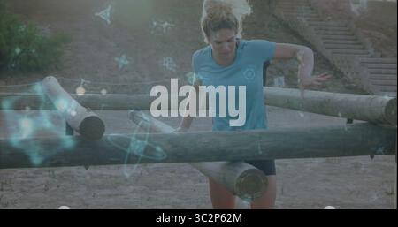 Maneuvering athletic woman navigating logs and hillside steps on dirt, with floating hologram icons. Fitness, outdoor training, obstacle course, augme Stock Photo
