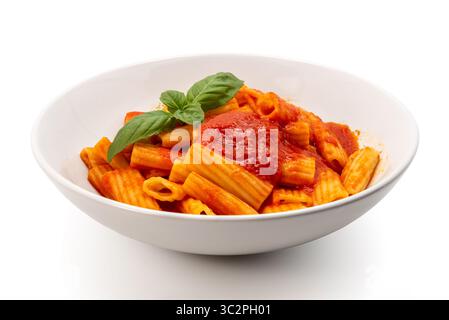 Macaroni rigatoni pasta with tomato sauce and green basil leaves on a white plate isolated on white with clipping path included Stock Photo