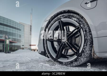 Car tires and rims of expensive luxury supercar on winter road covered with snow Stock Photo