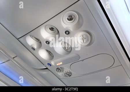 Close-Up of an Airplane Overhead Panel With Air Vents and Buttons. Overhead panel of a commercial airplane showing air vents, light buttons, and Stock Photo
