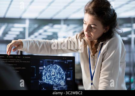 Manager overseeing worker doing data center automation using AI tools. Supervisor checking progress on employee integrating artificial intelligence driven automation in server hub operations Stock Photo