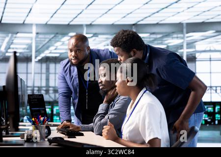 Team of data center office computer scientists using programming languages to construct algorithms and build applications. Teamworking server farm IT specialists debugging and optimizing code Stock Photo