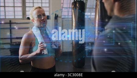 Catching breath woman wearing sportswear with towel in gym near punching bag with HUD, copy space Stock Photo