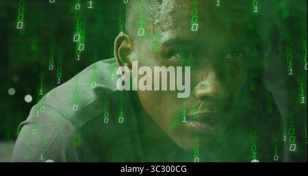 Analyzing code man wearing grey shirt leaning forward in digital scene, with flowing binary digits Stock Photo