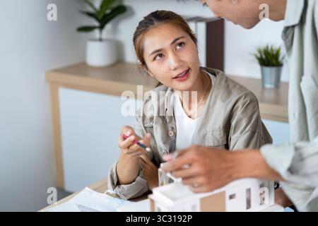Engaged Architects. Young professionals discussing a model and design ideas in a modern office. Stock Photo