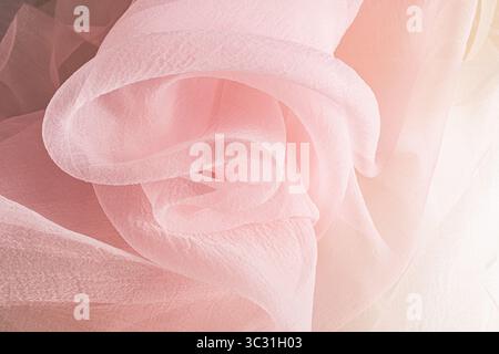 chic large waves of pink chiffon fabric. Delicate transparent fabric texture. elegantly twisted silk fabric. Festive background. Stock Photo