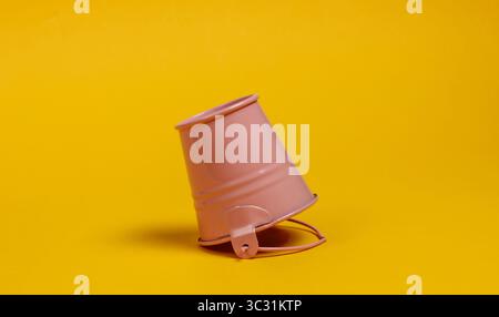 Inverted mini bucket on a yellow background close-up Stock Photo