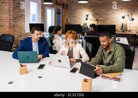 Multi ethnic team collaborating on project in modern office Stock Photo