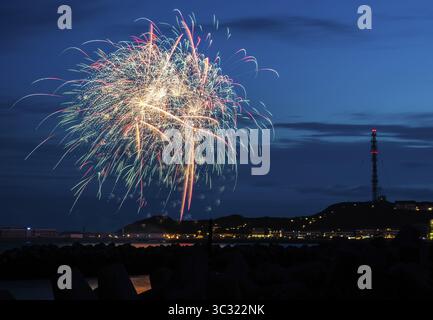 Brilliant, atmospheric fireworks display for the Heligoland island festival in red, blue and gold, nocturnal lowlands with inland harbour, jetty and l Stock Photo