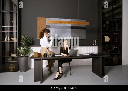 Two professionals working together in a modern office with stylish decor during the day Stock Photo