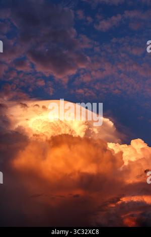 Storm clouds in evening sky, extreme weather scene with illuminated cumulonimbus formations Stock Photo