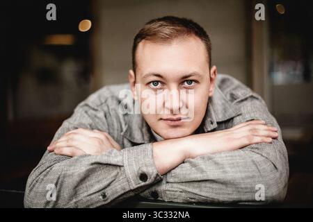 Man resting head on arms with calm expression Stock Photo
