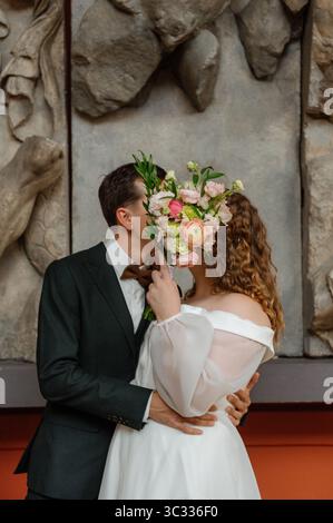 Couple sharing a romantic moment with flowers in a modern setting Stock Photo