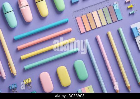 Stationery background with pastel-colored stationery neatly arranged on a light purple background. Stock Photo