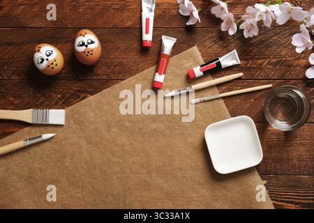 Painted eggs in the form of owls. Preparation for Easter celebration. Painting Easter eggs with acrylic pigment dyes in tubes. Copyspace. Stock Photo