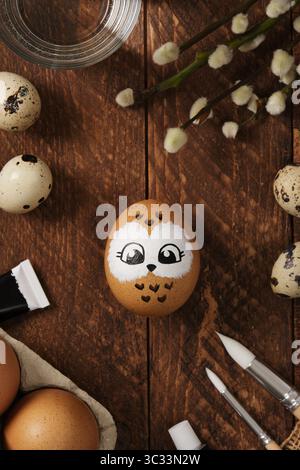 Hand drawn owl on an Easter egg on a wooden brown background Stock Photo