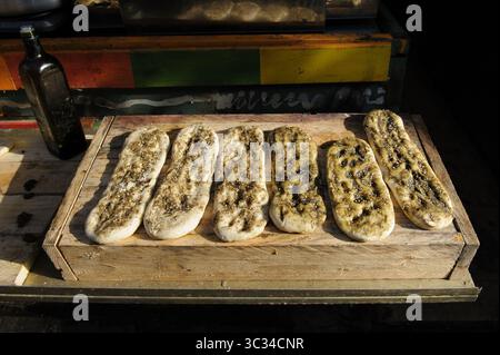 Freshly baked loaves of focaccia bread, a flat, leavened oven-baked Italian bread flavored with herbs and spices. Stock Photo
