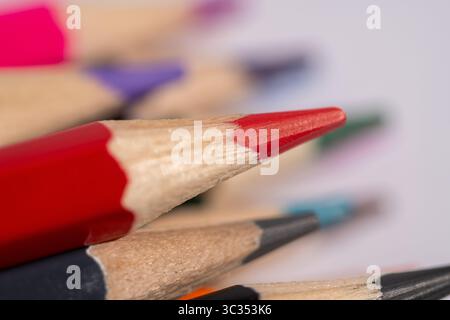 A close up of a bunch of pencils with one red one black and one blue. The pencils are all different colors and sizes Stock Photo