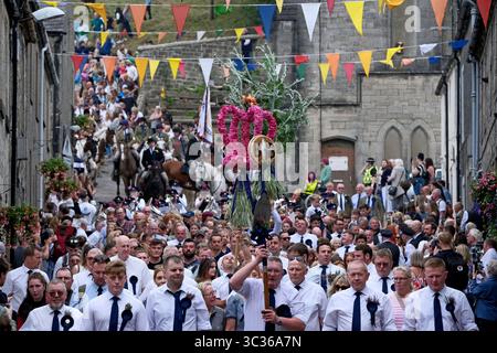 Langholm, UK. 25th July, 2025. Carrying the emblems of the Common Riding, a parade makes their way through the streets during the towns common riding on July 25, 2025 in Langholm, Scotland. A common riding is an equestrian tradition that mainly takes place in the Scottish Borders in Scotland where men and women ride out of the town and along its borders to commemorate the practices from the 13th and 15th centuries when there were frequent raids on the Anglo-Scottish border known as the Border Reivers. In Langholm this event dates back to 1759. ( Credit: Rob Gray/Alamy Live News Stock Photo