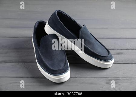 Pair of dark blue shoes on grey wooden surface, closeup Stock Photo