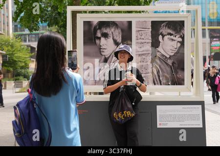 an-oasis-fan-poses-for-a-photo