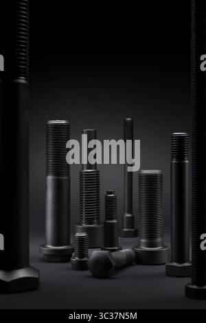 Variety of large black steel screws on black background. Stock Photo