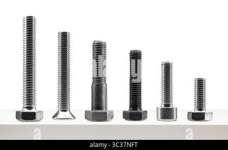 Variety of large steel screws on white table. Stock Photo