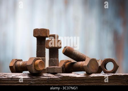 Group of old large rusty screws and bolts on wooden table. Stock Photo