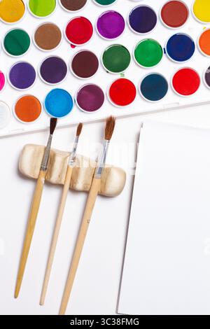 Paintbrushes and watercolor paints on a white background in a top view Stock Photo