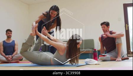 Guiding instructor assisting participant performing bow pose in bright studio, with yoga mats Stock Photo