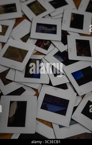 Old photo slides laying on a wooden table showing different pictures capturing memories Stock Photo